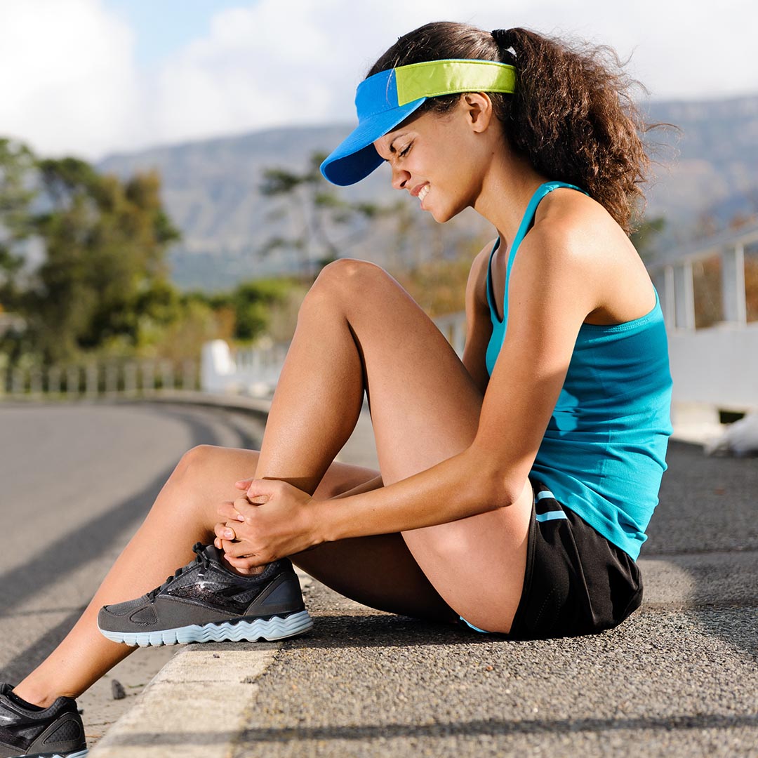 Woman holding her ankle in pain